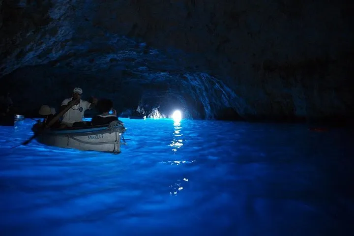 Small group boat waiting at the Blue Grotto entrance on a Capri Blue Grotto boat day tour from Sorrento, Italy